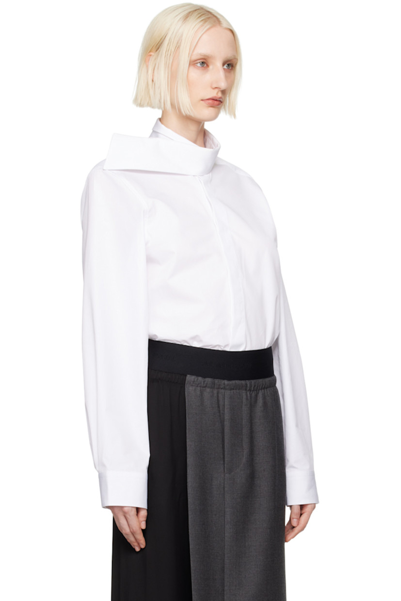 Cotton poplin shirt. 

· Modified stand collar
· Button closure 
· Shirttail hem
· Adjustable single-button barrel cuffs 
· Box-pleat at back yoke

Supplier color: White