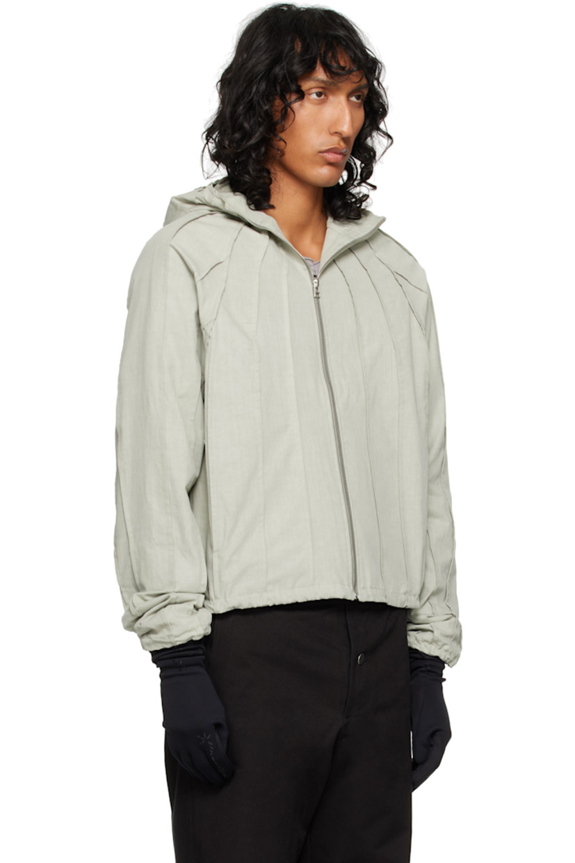 Cotton canvas jacket. Pinched seams throughout. 

· Funnel neck
· Zip closure
· Seam pockets
· Bungee-style drawstring at hem and cuffs
· Raglan sleeve

Supplier color: Laurel oak