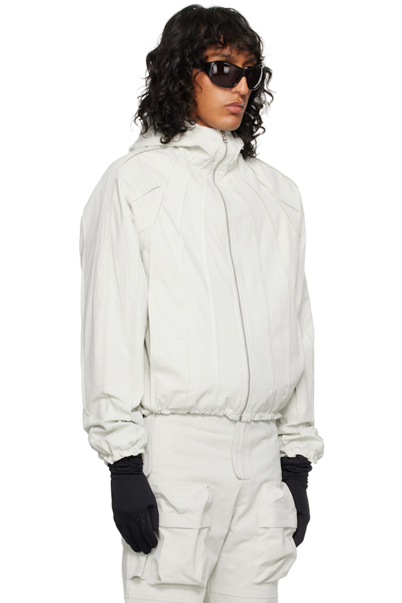 Cotton canvas jacket. Pinched seams throughout. 

· Funnel neck
· Zip closure
· Seam pockets
· Bungee-style drawstring at hem and cuffs
· Raglan sleeve

Supplier color: Vaporous gray