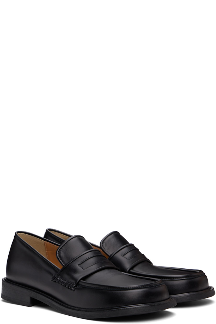 Buffed leather loafers in black.

· Moc toe
· Strap at vamp
· Cushioned Ortholite® footbed
· Buffed leather and suede lining
· Stacked leather heel and midsole
· Textured Vibram® rubber sole
· Heel: H1"

Supplier color: Black