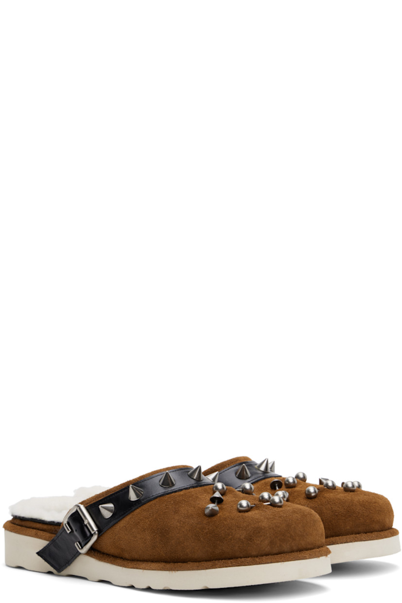 Suede slippers in brown. 

· Graphic hardware at toe
· Studded pin-buckle strap at collar 
· Sherpa fleece lining 
· Foam rubber midsole
· Lugged rubber sole

Supplier color: Camel suede