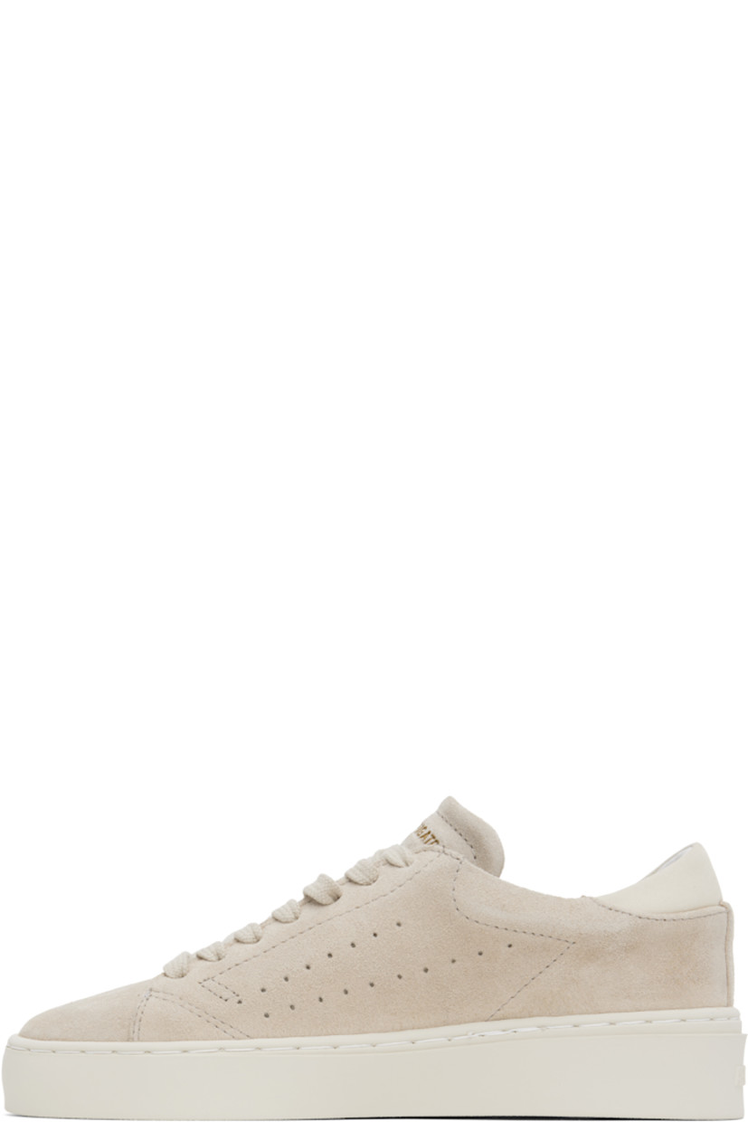 Handcrafted low-top buffed suede sneakers in taupe. 

· Lace-up closure
· Logo embossed at padded tongue and outer side
· Padded collar
· Perforated detailing at sides
· Nubuck heel tab
· Logo embossed at heel
· Buffed leather and faux-suede lining
· Treaded rubber sole

Supplier color: Off white/Off white