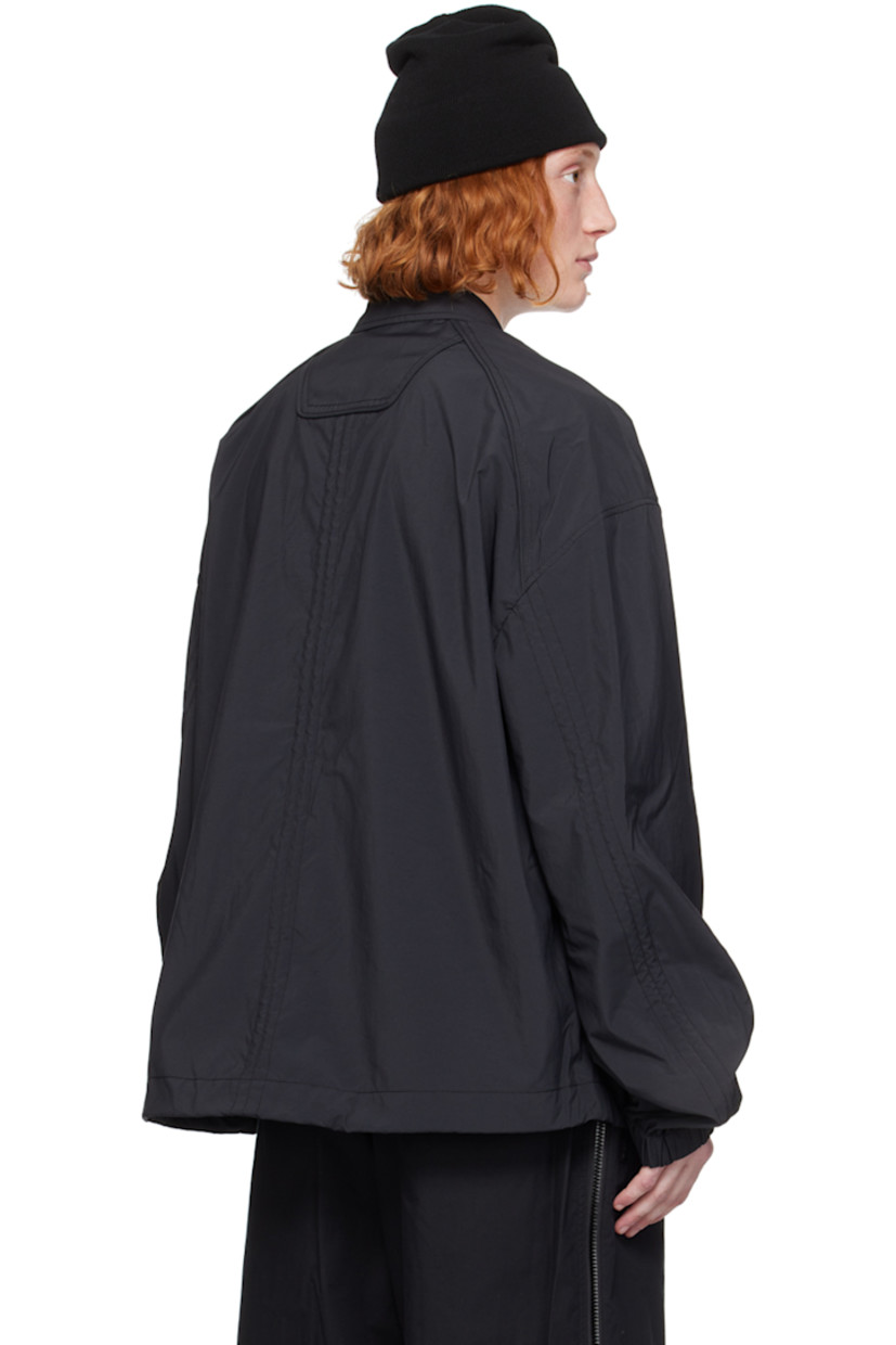 Loose-fit polyester poplin shirt.

· Spread collar
· Concealed button closure
· Logo embroidered at chest
· Welt pockets
· Bungee-style drawstring at hem 
· Piping at raglan sleeves
· Elasticized cuffs
· Central seam at back

Supplier color: Black
