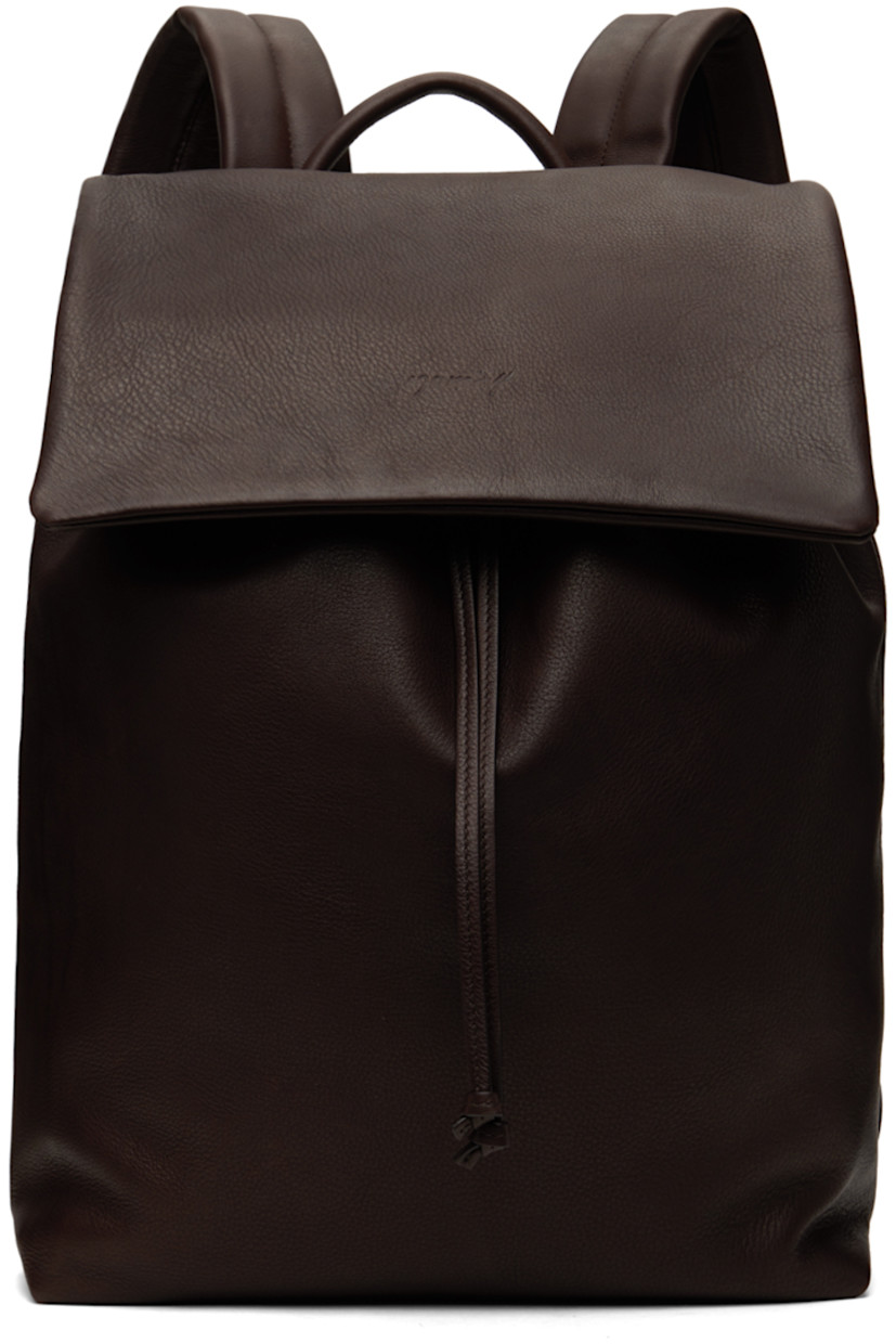 Grained leather backpack in brown.

· Carry handle
· Padded adjustable shoulder straps
· Luggage strap at back face
· Logo embossed at flap
· Drawstring closure
· Zip pocket at interior
· Nappa leather lining
· H15" x W13.5" x D5.75"

Supplier color: Dark brown
