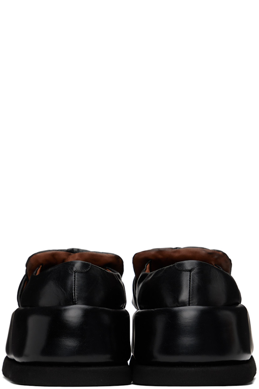 Handcrafted padded buffed calfskin loafers in black.

· Moc toe
· Strap at vamp
· Logo embossed at leather footbed
· Buffed leather and suede lining 
· Covered platform midsole
· Treaded foam rubber sole 
· Platform: H2.5"

Supplier color: Black