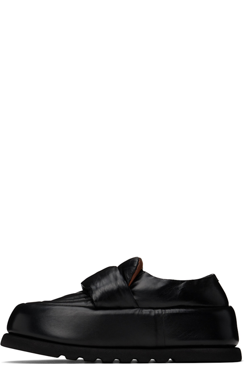 Handcrafted padded buffed calfskin loafers in black.

· Moc toe
· Strap at vamp
· Logo embossed at leather footbed
· Buffed leather and suede lining 
· Covered platform midsole
· Treaded foam rubber sole 
· Platform: H2.5"

Supplier color: Black