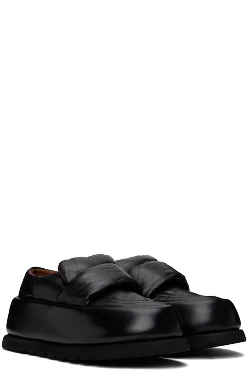 Handcrafted padded buffed calfskin loafers in black.

· Moc toe
· Strap at vamp
· Logo embossed at leather footbed
· Buffed leather and suede lining 
· Covered platform midsole
· Treaded foam rubber sole 
· Platform: H2.5"

Supplier color: Black