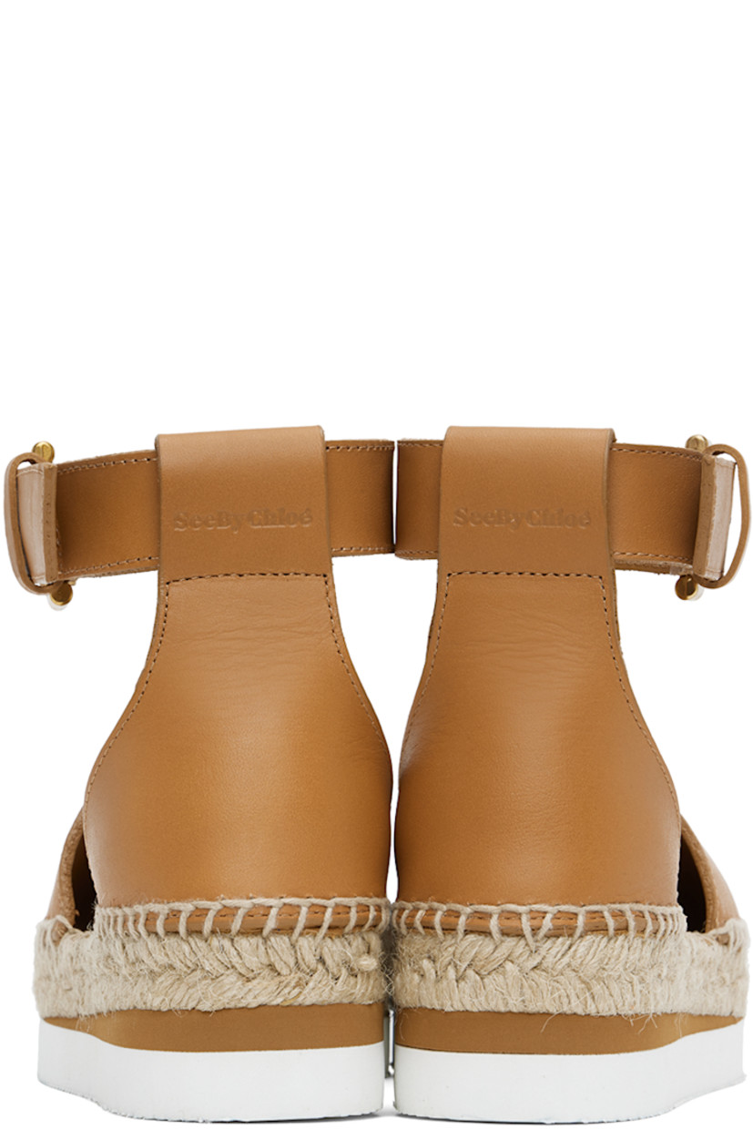 Grained calfskin espadrilles in tan. 

· Pin-buckle ankle strap
· Logo embossed at heel tab
· Logo embossed at padded leather footbed
· Suede and buffed leather lining
· Blanket stitching at welt
· Braided jute midsole
· Treaded foam rubber platform sole
· Platform: H1.25"

Supplier color: Tan