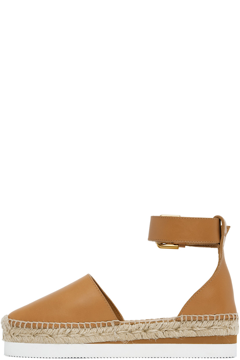 Grained calfskin espadrilles in tan. 

· Pin-buckle ankle strap
· Logo embossed at heel tab
· Logo embossed at padded leather footbed
· Suede and buffed leather lining
· Blanket stitching at welt
· Braided jute midsole
· Treaded foam rubber platform sole
· Platform: H1.25"

Supplier color: Tan