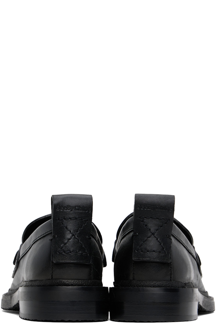 Grained calfskin loafers in black. 

· Moc toe
· Logo plaque at vamp
· Logo-embossed pull-loop at heel tab
· Topstitching at heel counter and welt 
· Stacked leather heel 
· Crepe rubber sole 

Supplier color: Black