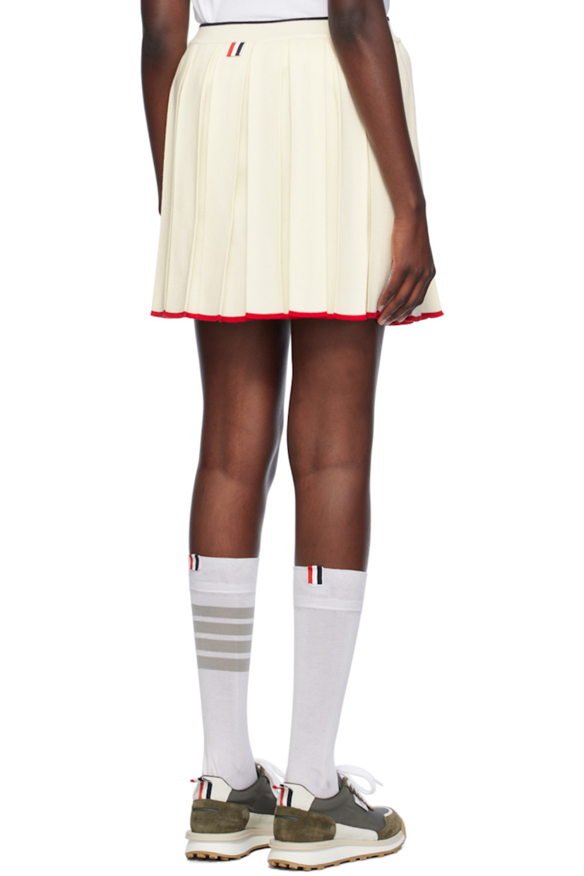 Knit virgin wool-blend skirt. Box pleats throughout.

· Rib knit elasticized waistband
· Stripe at waistband and hem
· Tricolor grosgrain flag at back waistband 

Supplier color: White