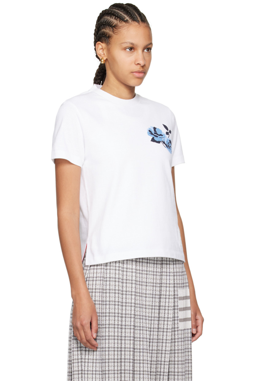 Stretch cotton jersey T-shirt. 

· Rib knit crewneck
· Floral graphic printed at chest 
· Logo patch at front hem
· Droptail hem 
· Vented side seams
· Tricolor grosgrain flag at back collar

Supplier color: White