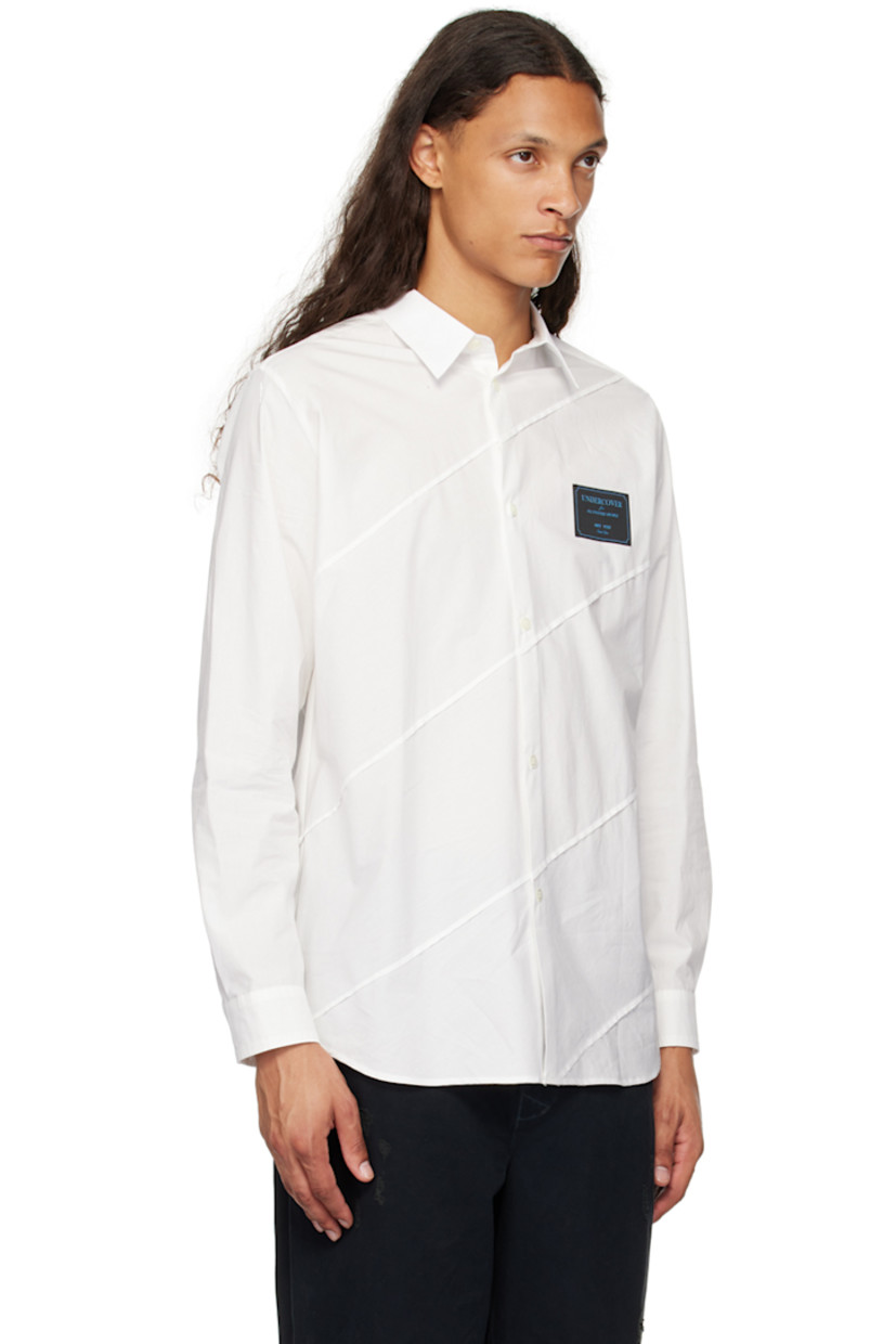 Cotton oxford cloth shirt. Raw edges throughout.

· Paneled construction
· Spread collar
· Button closure
· Logo patch at chest
· Shirttail hem
· Single-button barrel cuffs

Supplier color: White