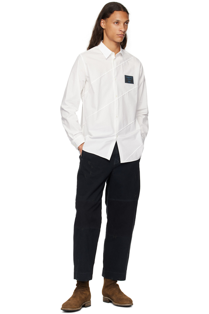 Cotton oxford cloth shirt. Raw edges throughout.

· Paneled construction
· Spread collar
· Button closure
· Logo patch at chest
· Shirttail hem
· Single-button barrel cuffs

Supplier color: White