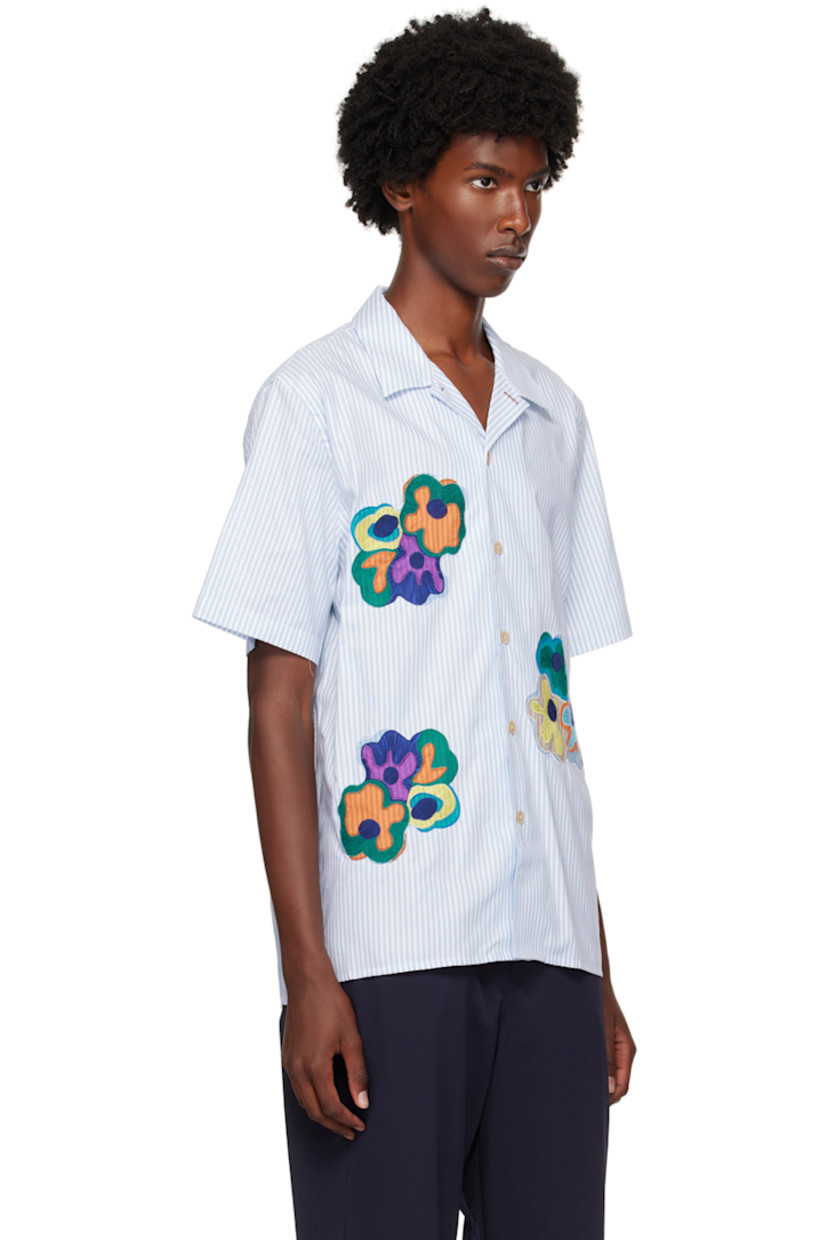 GOTS-certified organic cotton oxford cloth shirt.

· Open spread collar
· Button closure
· Embroidered appliqués at front
· Logo flag at side seam

Supplier color: Blues