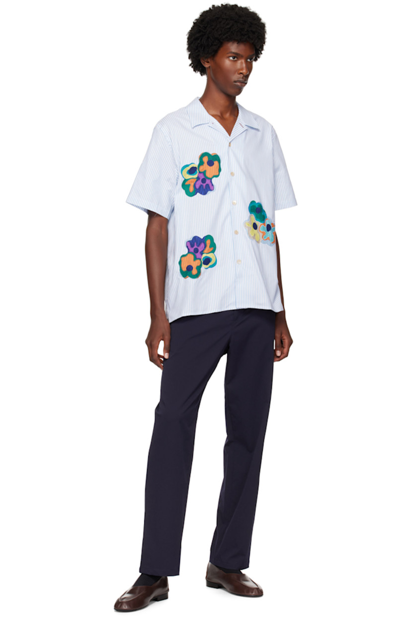 GOTS-certified organic cotton oxford cloth shirt.

· Open spread collar
· Button closure
· Embroidered appliqués at front
· Logo flag at side seam

Supplier color: Blues