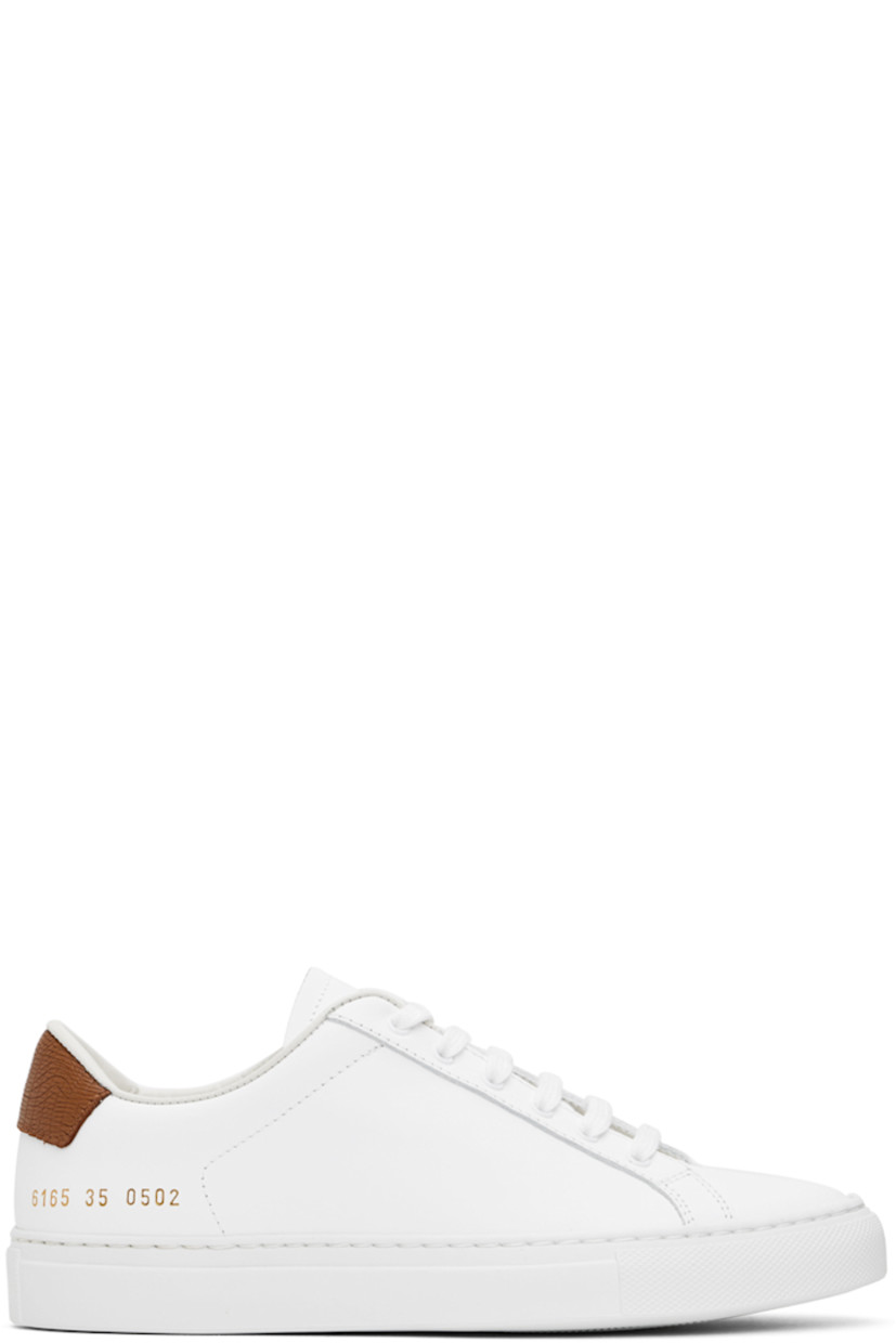 Low-top buffed leather sneakers in white. 

· Lace-up closure
· Padded tongue and collar
· Signature series stamp at outer side
· Grained leather heel tab
· Suede and canvas lining
· Textured rubber midsole
· Treaded rubber sole

Supplier color: White/Tan