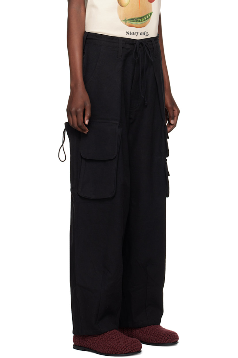 Oversized kaduka- and iron-dyed slub organic cotton hopsack trousers.

· Belt loops and drawstring at waistband
· Three-pocket styling
· Zip-fly
· Pleats at front
· Hand-embroidered logo at leg
· Darts at cuffs
· Bellows pockets at outseams
· Dyed corozo hardware

Supplier color: Black slub