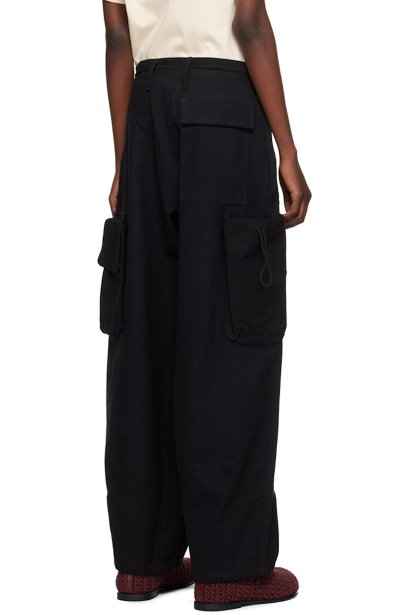 Oversized kaduka- and iron-dyed slub organic cotton hopsack trousers.

· Belt loops and drawstring at waistband
· Three-pocket styling
· Zip-fly
· Pleats at front
· Hand-embroidered logo at leg
· Darts at cuffs
· Bellows pockets at outseams
· Dyed corozo hardware

Supplier color: Black slub