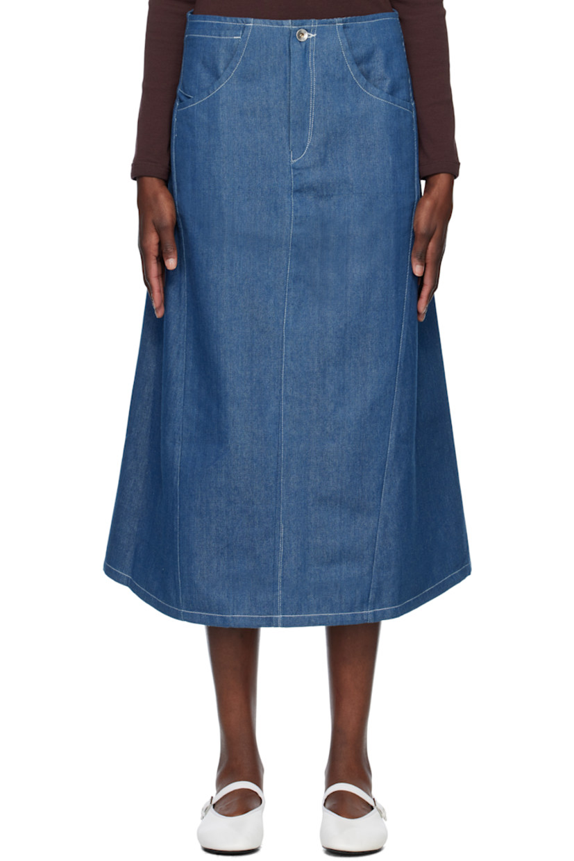 Handcrafted non-stretch organic cotton denim midi skirt. 

· Four-pocket styling
· Zip-fly
· Curved side seams
· Embroidered logo patch at back pocket
· Gusset at back hem
· Contrast stitching in white

Supplier color: Indigo Wonky Denim