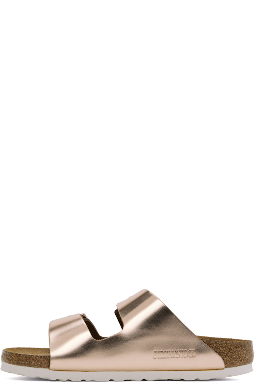 Buffed leather slip-on flat sandals in metallic copper tone.

· Open toe
· Pin-buckle straps at vamp
· Logo embossed at inner side
· Logo printed at cushioned molded suede footbed
· Cork-latex midsole
· Treaded EVA rubber sole
· Logo-engraved antiqued copper-tone hardware

Supplier color: Metallic copper