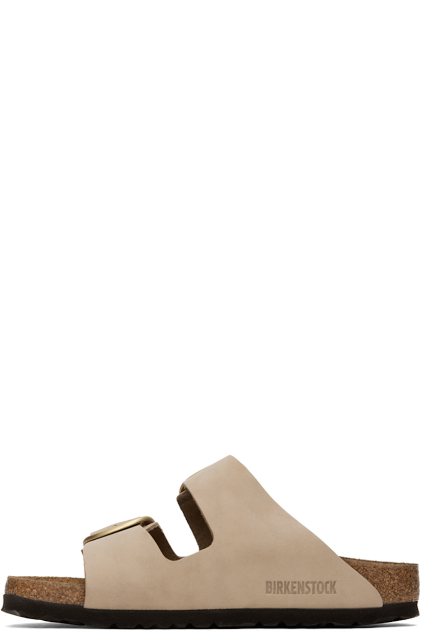 Nubuck slip-on sandals in taupe. 

· Open toe
· Pin-buckle straps at vamp
· Logo embossed at inner side
· Logo stamp at molded suede footbed
· Cork midsole
· Treaded EVA rubber sole
· Logo-engraved gold-tone hardware

Supplier color: Sandcastle