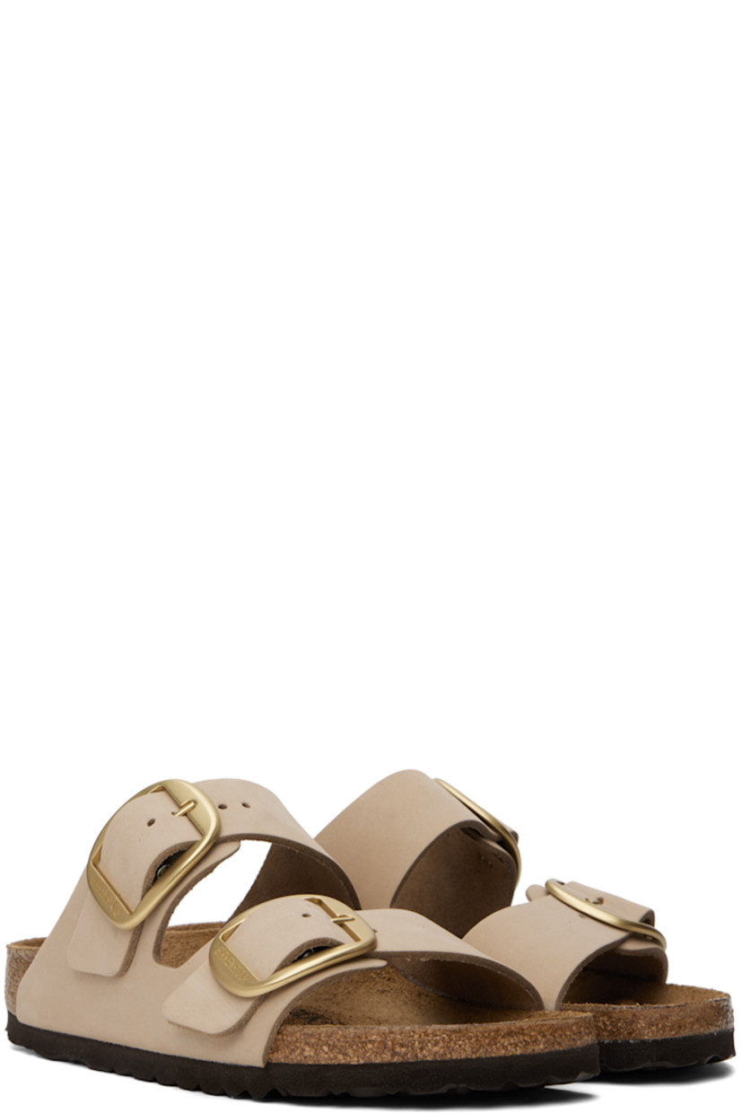Nubuck slip-on sandals in taupe. 

· Open toe
· Pin-buckle straps at vamp
· Logo embossed at inner side
· Logo stamp at molded suede footbed
· Cork midsole
· Treaded EVA rubber sole
· Logo-engraved gold-tone hardware

Supplier color: Sandcastle