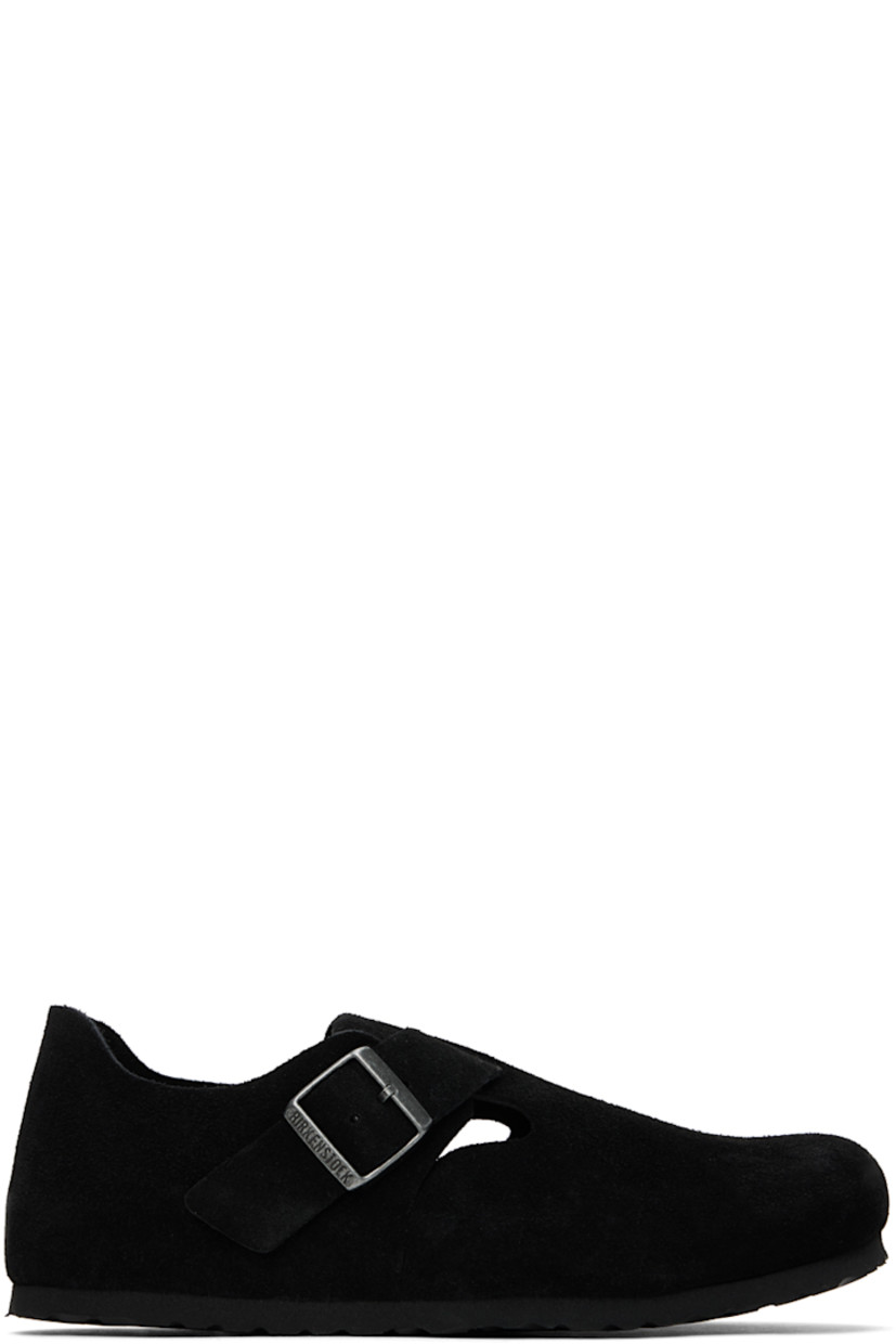 Suede loafers in black. 

· Adjustable pin-buckle strap at vamp
· Logo embossed at inner side
· Logo embossed at molded suede footbed
· Cork midsole
· Treaded EVA rubber sole
· Logo-engraved antiqued silver-tone hardware

Supplier color: Black suede