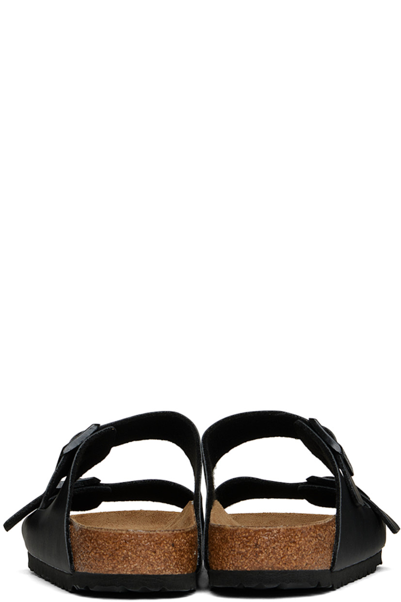 Grained Birko-Flor® faux-leather slip-on sandals in black.

· Open toe
· Pin-buckle straps at vamp
· Logo embossed at inner side
· Logo stamp at molded suede footbed
· Latex-cork midsole
· Treaded EVA outsole
· Logo-engraved black hardware

Supplier color: Black