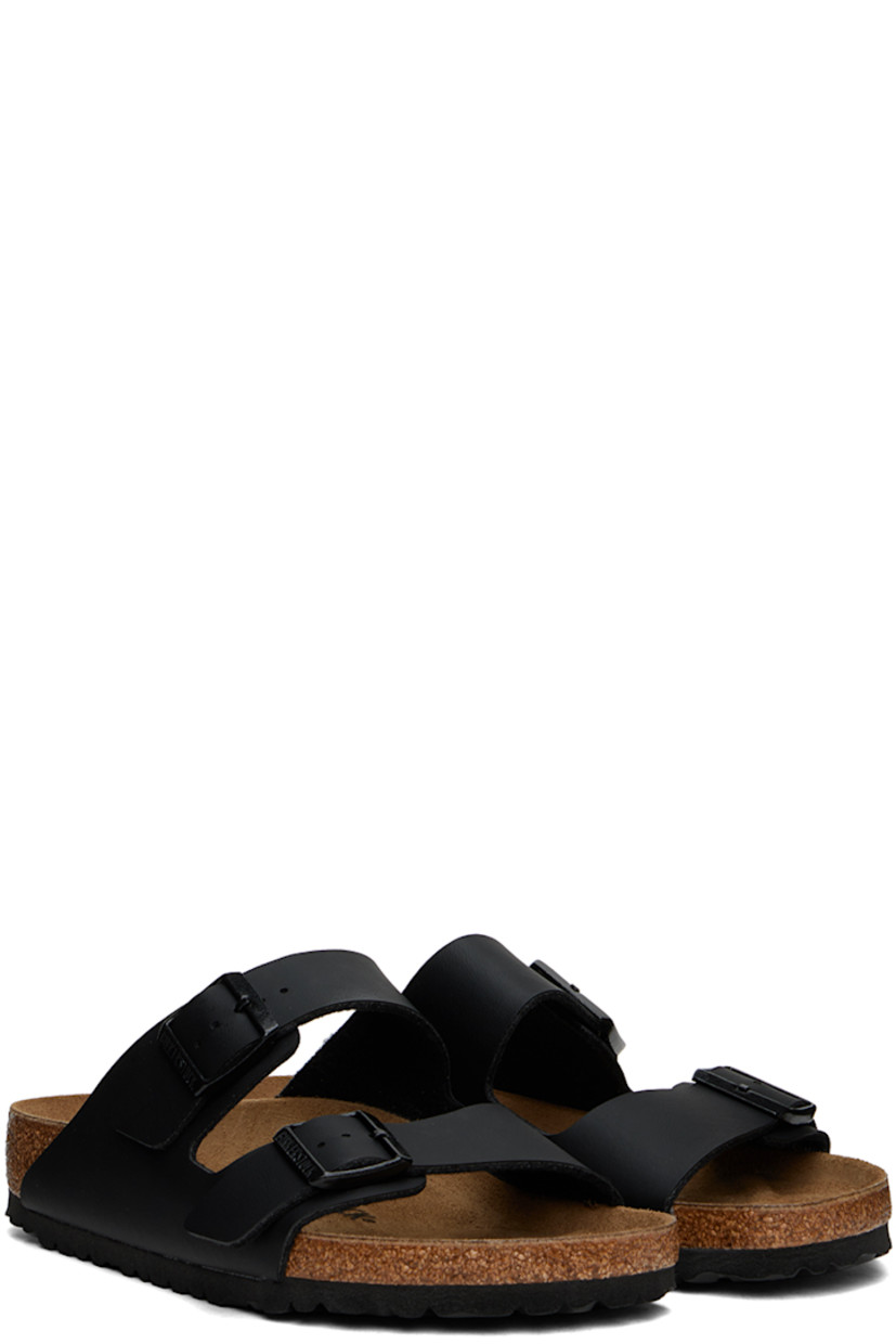 Grained Birko-Flor® faux-leather slip-on sandals in black.

· Open toe
· Pin-buckle straps at vamp
· Logo embossed at inner side
· Logo stamp at molded suede footbed
· Latex-cork midsole
· Treaded EVA outsole
· Logo-engraved black hardware

Supplier color: Black
