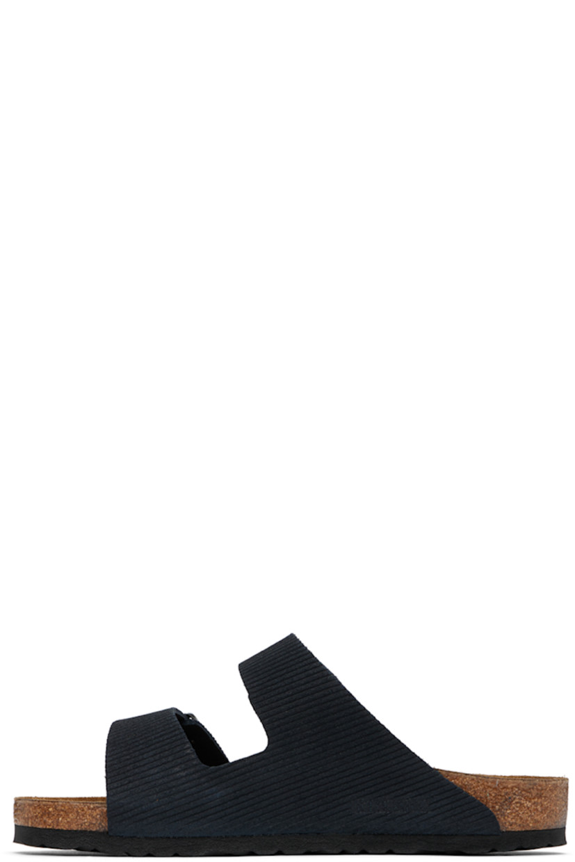 Corduroy-embossed suede slip-on sandals in navy.

· Open toe
· Adjustable pin-buckle straps at vamp
· Logo embossed at inner side
· Logo stamp at molded suede footbed
· Cork midsole
· Treaded EVA rubber sole
· Logo-engraved antiqued gold-tone hardware

Supplier color: Midnight corduroy