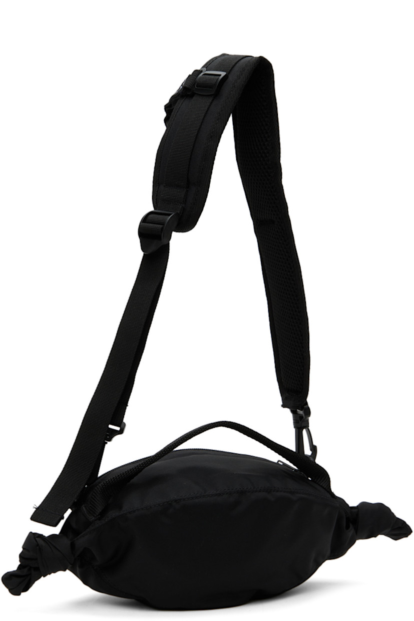 Canvas messenger bag in black.

· Webbing carry handle
· Padded detachable and adjustable shoulder strap
· D-ring and daisy chain at shoulder strap
· Graphic appliqués at face
· Bouclé logo appliqué at face 
· Knotted accent at sides
· Zip closure
· Canvas lining
· H4" x W11" x D4"

Supplier color: Black