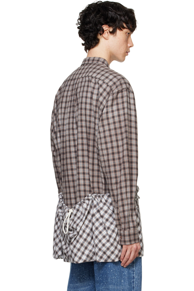 Overdyed cotton flannel shirt. Check pattern throughout.

· Spread collar
· Button closure
· Patch pocket at chest
· Welt pockets
· Drawstring and patch pockets at hem
· Pleats at single-button barrel cuffs
· Box pleat at back yoke

Supplier color: Brown check