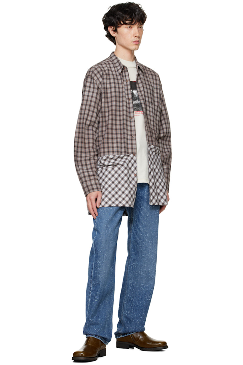 Overdyed cotton flannel shirt. Check pattern throughout.

· Spread collar
· Button closure
· Patch pocket at chest
· Welt pockets
· Drawstring and patch pockets at hem
· Pleats at single-button barrel cuffs
· Box pleat at back yoke

Supplier color: Brown check