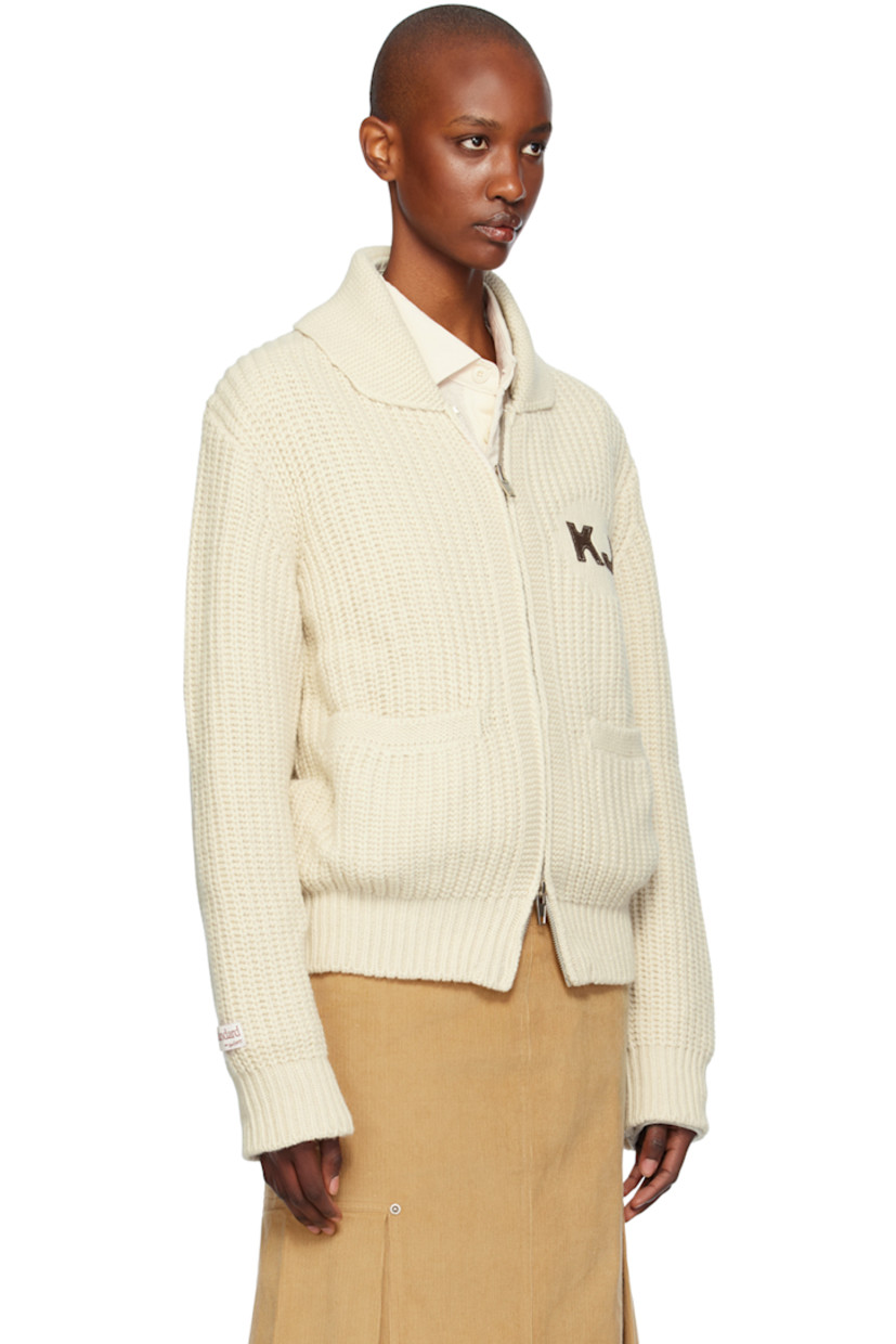 Rib knit wool- and nylon-blend cardigan. 

· Shawl collar
· Two-way zip closure
· Logo patch at chest and back collar
· Welt pockets
· Raglan sleeves
· Logo patch at sleeve
· Text appliqué at back

Supplier color: Ivory