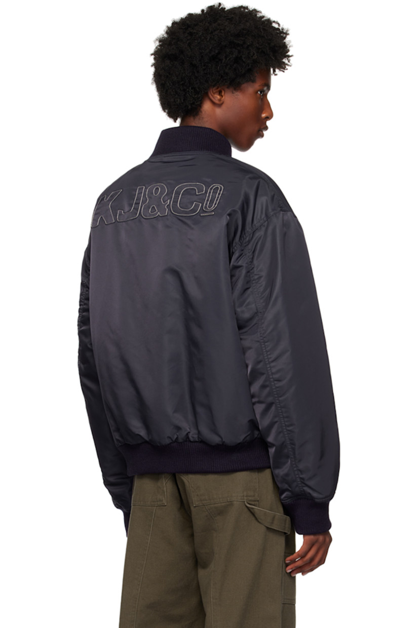 Padded nylon taffeta bomber jacket.

· Rib knit stand collar, hem, and cuffs
· Two-way zip closure
· Logo embroidered at chest 
· Flap pockets 
· Logo patch at hem
· Utility pocket at sleeve
· Logo appliqués at back
· Welt pockets at interior
· Full satin lining 
· Silver-tone hardware

Supplier color: Navy