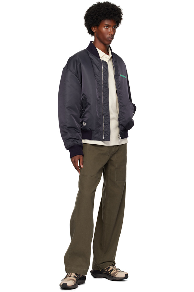 Padded nylon taffeta bomber jacket.

· Rib knit stand collar, hem, and cuffs
· Two-way zip closure
· Logo embroidered at chest 
· Flap pockets 
· Logo patch at hem
· Utility pocket at sleeve
· Logo appliqués at back
· Welt pockets at interior
· Full satin lining 
· Silver-tone hardware

Supplier color: Navy