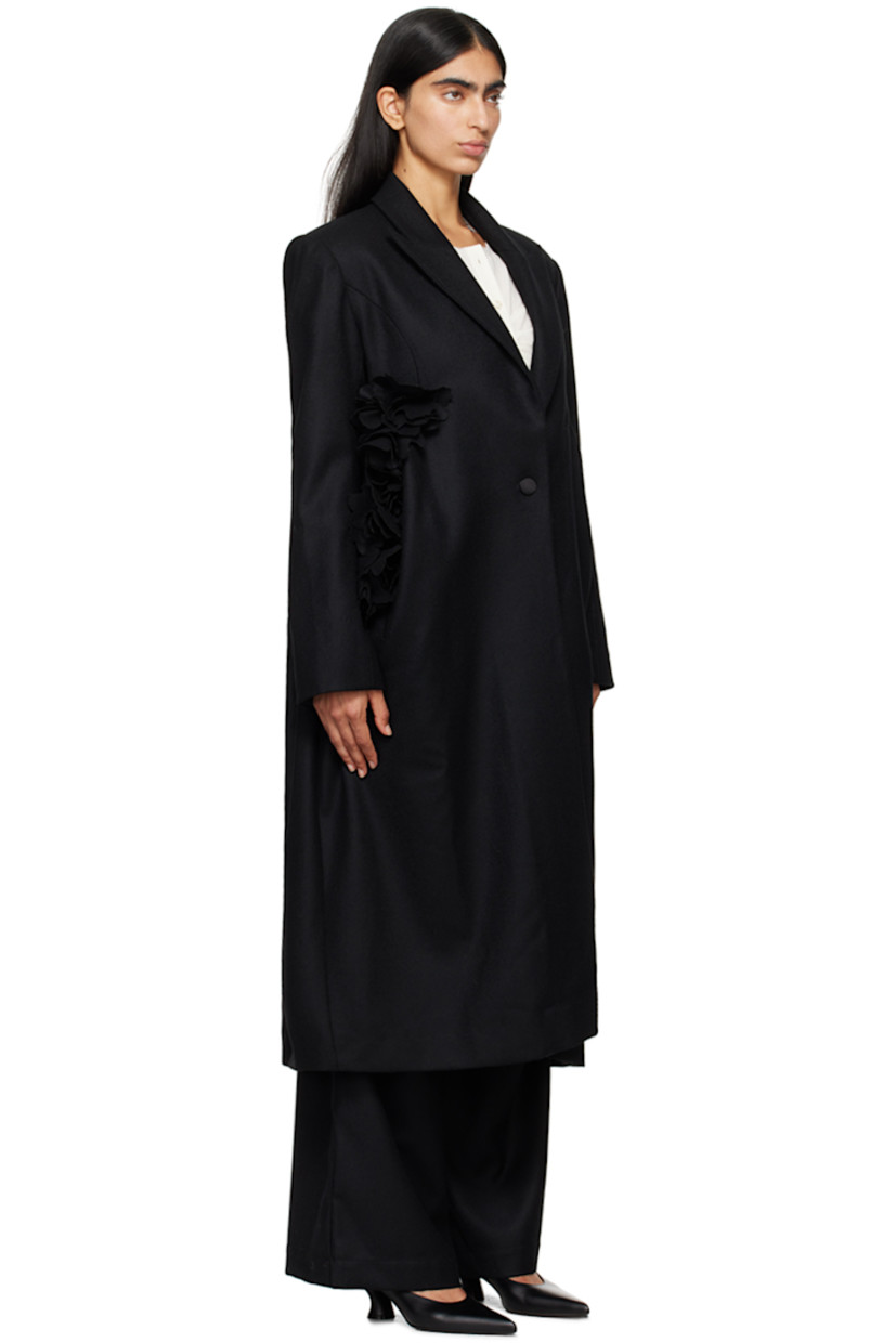 Wool melton coat. 

· Peaked lapel
· Single-button closure
· Floral appliqué at front
· Welt pockets
· Padded shoulders
· Three-button surgeon's cuffs
· Central vent at back hem 
· Full twill lining

Supplier color: Black