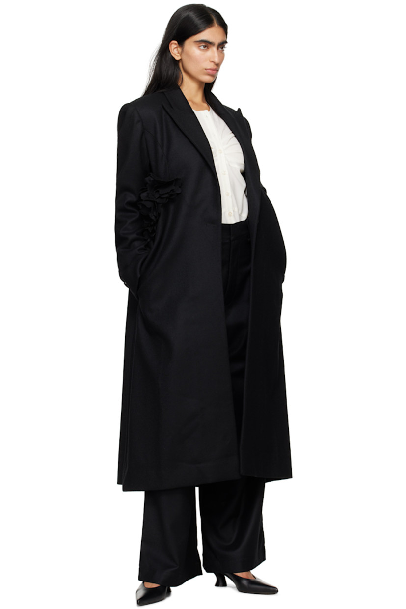 Wool melton coat. 

· Peaked lapel
· Single-button closure
· Floral appliqué at front
· Welt pockets
· Padded shoulders
· Three-button surgeon's cuffs
· Central vent at back hem 
· Full twill lining

Supplier color: Black