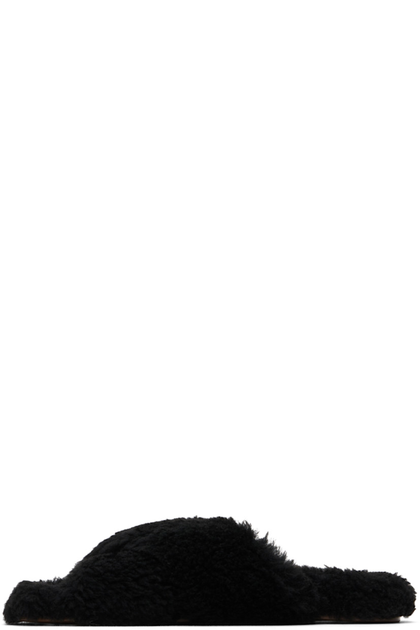 Shearling slippers in black.

· Open toe
· Criss-crossing straps at vamp
· Logo-embossed leather patch at footbed
· Treaded rubber sole

Supplier color: Black