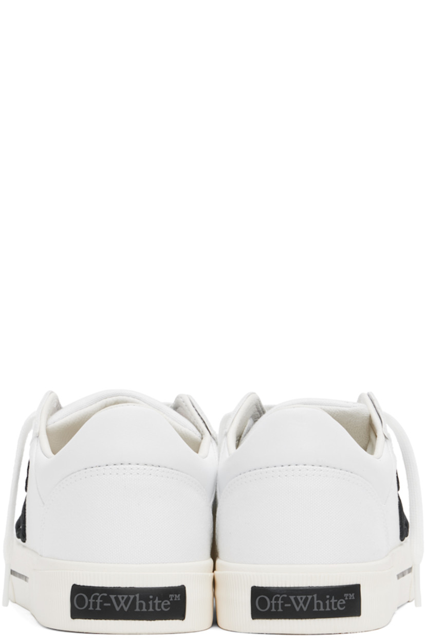 Low-top paneled canvas sneakers in white. 

· Signature zip-tie at lace-up closure
· Leather logo patch at padded tongue
· Padded collar
· Logo embroidered at outer side
· Rubber logo patch at heel
· Grained leather and suede lining
· Textured rubber midsole 
· Treaded vulcanized rubber sole

Supplier color: White/Black