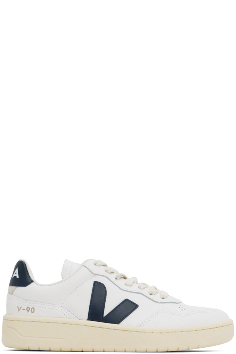Low-top grained Organic Traced leather sneakers in white and navy.

· Perforated detailing at toe
· Organic cotton lace-up closure
· Logo printed at padded tongue
· Padded collar
· Rubberized logo appliqué at sides
· Gold-tone text printed at outer side
· Logo printed at heel tab
· Suede trim at heel counter
· Jersey lining
· Treaded rubber sole

Supplier color: White/Nautico