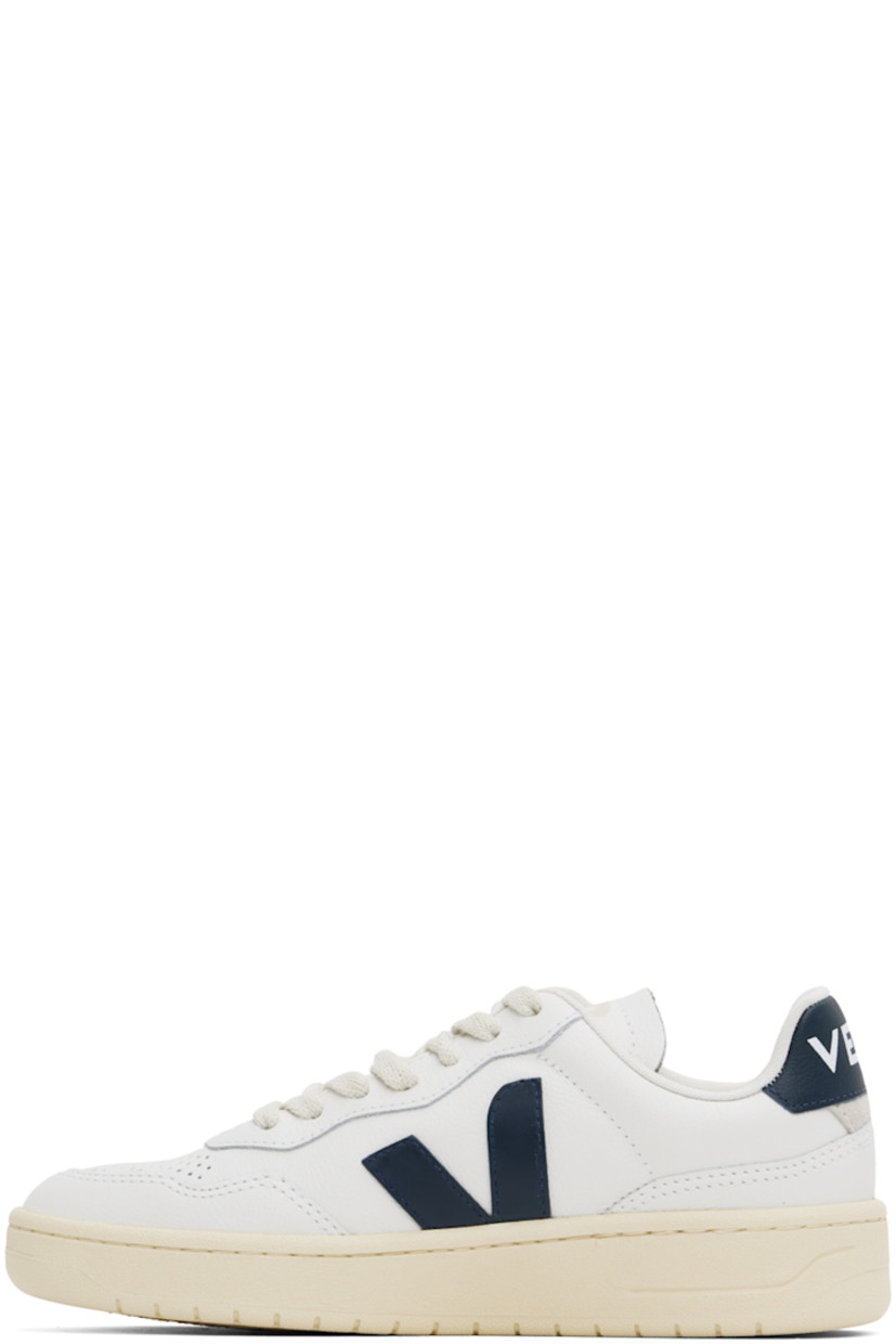 Low-top grained Organic Traced leather sneakers in white and navy.

· Perforated detailing at toe
· Organic cotton lace-up closure
· Logo printed at padded tongue
· Padded collar
· Rubberized logo appliqué at sides
· Gold-tone text printed at outer side
· Logo printed at heel tab
· Suede trim at heel counter
· Jersey lining
· Treaded rubber sole

Supplier color: White/Nautico