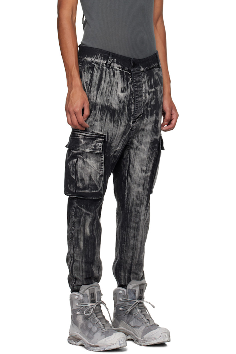 Garment-dyed stretch denim cargo pants. Fading and graphic pattern printed throughout.

· Belt loops
· Concealed drawstring at waistband
· Four-pocket styling
· Offset button-fly
· Concealed elasticized stirrup at cuffs
· Gusset at dropped inseam
· Bellows pocket at outseams
· Extended trim at back

Supplier color: Black