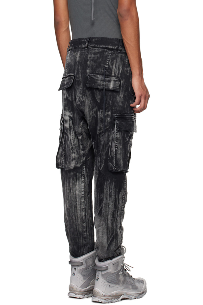Garment-dyed stretch denim cargo pants. Fading and graphic pattern printed throughout.

· Belt loops
· Concealed drawstring at waistband
· Four-pocket styling
· Offset button-fly
· Concealed elasticized stirrup at cuffs
· Gusset at dropped inseam
· Bellows pocket at outseams
· Extended trim at back

Supplier color: Black