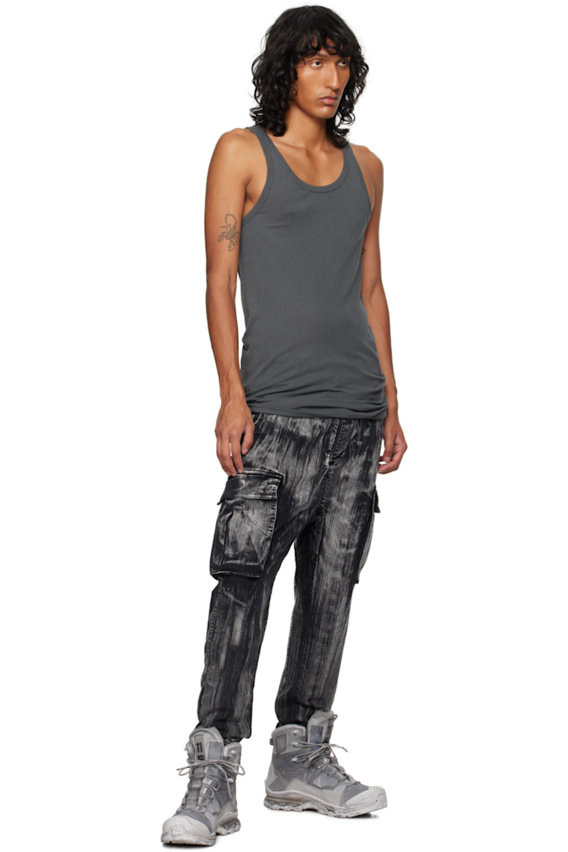 Garment-dyed stretch denim cargo pants. Fading and graphic pattern printed throughout.

· Belt loops
· Concealed drawstring at waistband
· Four-pocket styling
· Offset button-fly
· Concealed elasticized stirrup at cuffs
· Gusset at dropped inseam
· Bellows pocket at outseams
· Extended trim at back

Supplier color: Black