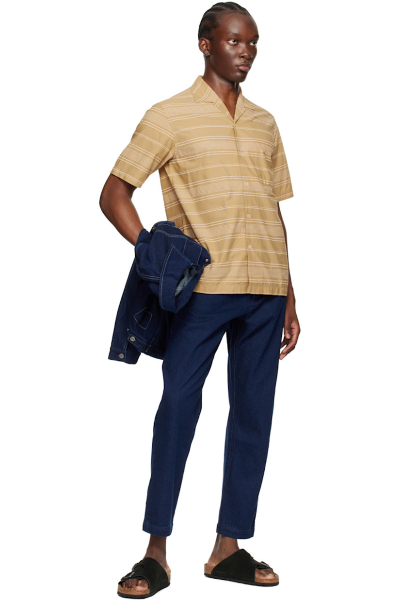 Cotton seersucker shirt. Stripes throughout.

· Open spread collar
· Button closure
· Patch pocket 
· Tennis-tail hem

Supplier color: Sand