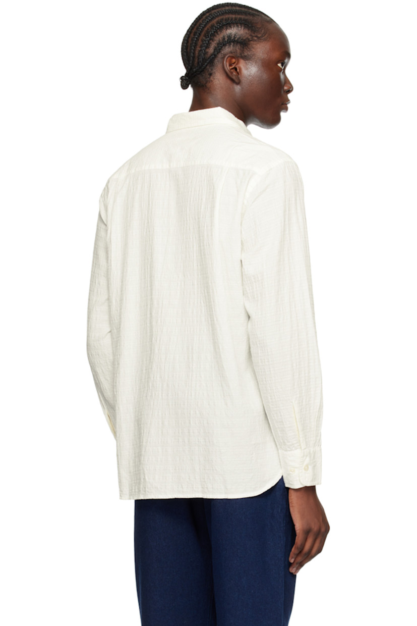 Organic cotton dobby cloth shirt.

· Spread collar
· Button closure
· Patch pocket at chest
· Droptail hem
· Adjustable single-button barrel cuffs
· Pleats at back yoke

Supplier color: Ecru