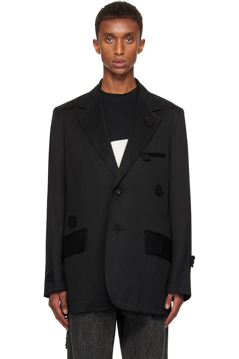 Wool drill blazer. Hand-woven cotton floral accents throughout.

· Notched lapel
· Button closure
· Welt pocket and flap pockets
· Padded shoulders
· Raw edge at sleeves and back
· Central vent at back hem
· Welt pockets at interior
· Full cupro satin lining

Supplier color: Black