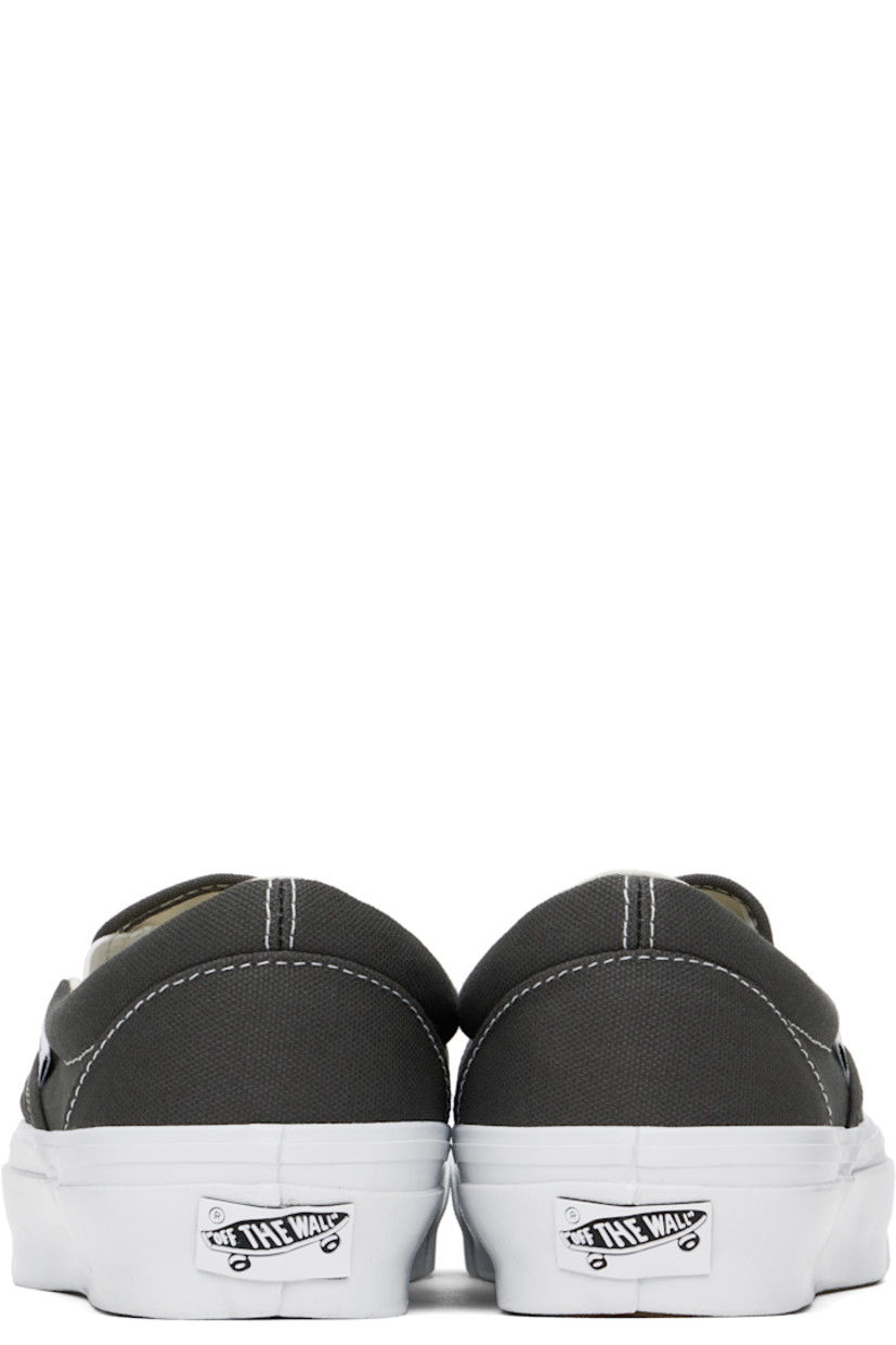 Low-top canvas slip-on sneakers in gray.

· Elasticized gussets at tongue
· Padded collar
· Logo flag at outer side
· Rubberized logo patch at heel
· Canvas lining
· Removable padded foam insole
· Treaded rubber sole
· Contrast stitching in white

Supplier color: Gunmetal